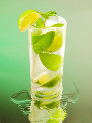 mojito isolated cocktail on a black glass with green degradation on the background.