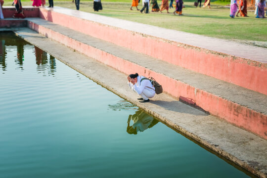 Young woman sitting in prayer at Maya Devi Temple in Lumbini, Nepal.