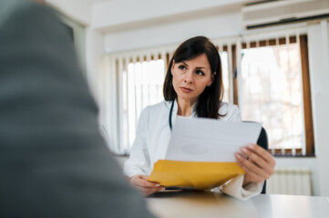 Portrait of a serious doctor looking at test results of a patient.