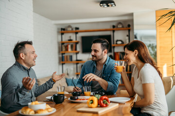 Friends eating breakfast together at home.