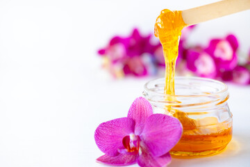 depilation and beauty concept - sugar paste or wax honey for hair removing flows down from wooden...
