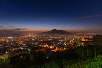 Fototapeta premium Lettere, Italy. May 12th, 2020. Panoramic view of Mount Vesuvius seen from the village of Lettere after sunset with night lights.