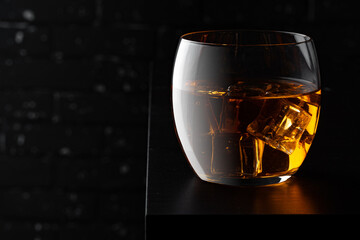 Whisky glass against dark black grunge wall