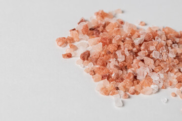 A pile of Himalayan pink salt crystals on a white background.