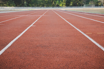 Empty red running track in stadium. Sport and exercise concept