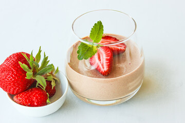 Chocolate dessert decorated with strawberries and Melissa leaves