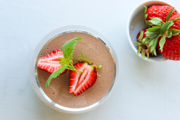 Chocolate dessert decorated with strawberries and Melissa leaves