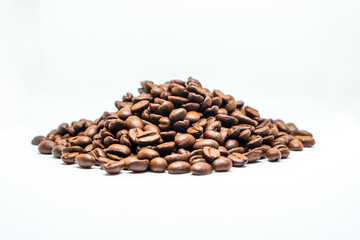 Brown dark roasted coffee beans isolated on white background. Group agriculture seed nature grain arabica.