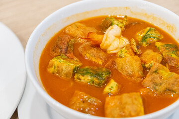 Acacia omelets and fresh shrimp in vegetable sour soup at restaurant. Deep fried cha om leaves with sour curry. Kang som cha om koong very spicy of asian traditional style. Thai cuisine top view