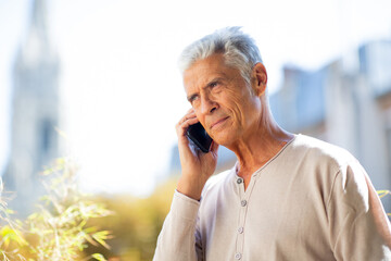 Close up handsome older man talking with cellphone outside