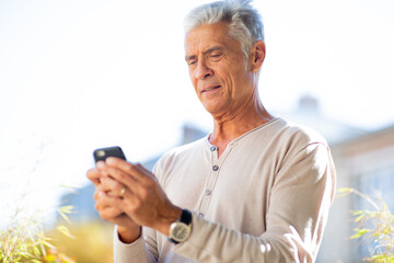 Close up handsome older man looking at mobile phone