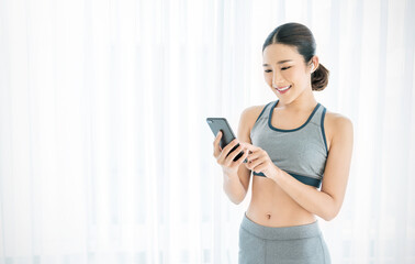 Portrait of sporty asian fitness woman listen to music from smartphone with bluetooth wireless...