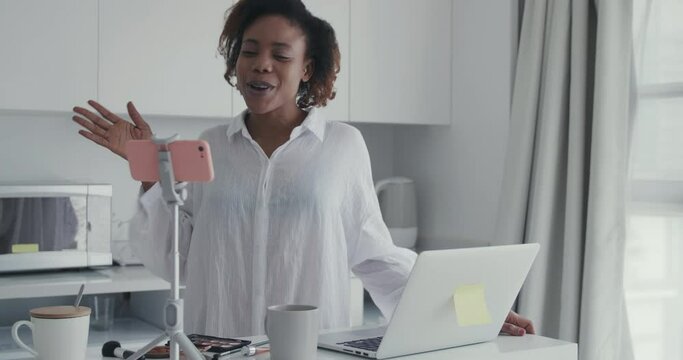 pretty African makeup internet influencer working online videoing beauty tutorial at home a beauty makeup master teaching and explaining makeup techniques chatting with people online living broadcast