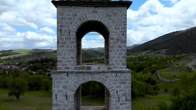 Stone church bell tower with arched windows and beautiful view on mountains and hills in Voskopoja, Albania