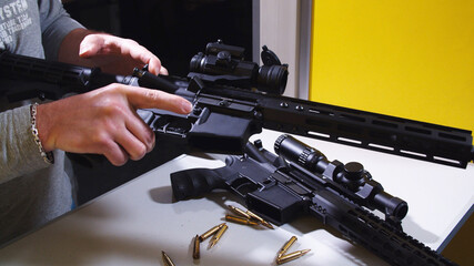 Shooting instructor loading an assault rifle at a shooting range. High quality photo