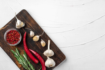 Red chili peppers and other spices on white textured background, top view