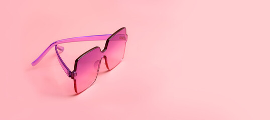 stylish pink eyeglass on pink background. Creative minimal style concept. banner. copy space. 
