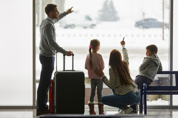 Familie und Kinder im Flughafen beobachten Flugzeuge