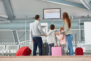 Familie auf der Reise schaut auf Flughafen Anzeigetafel