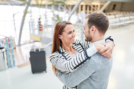 Gl&uuml;ckliches Paar im Flughafen Terminal umarmt sich
