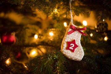 Traditional Advent Calendar Stocking with the date of the second of December hanging on a traditional christmas tree.