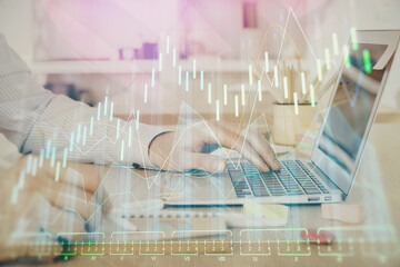 Multi exposure of stock market graph with man working on laptop on background. Concept of financial analysis.