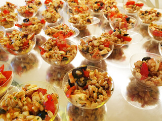 A light snack for a buffet of barley porridge (orzotto) with seafood, tomatoes and olives.