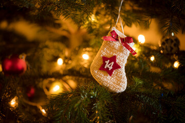 Traditional Advent Calendar Stocking with the date of the fourteenth of December hanging on a traditional christmas tree.