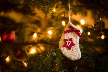 Traditional Advent Calendar Stocking with the date of the 17th of December hanging on a traditional christmas tree.