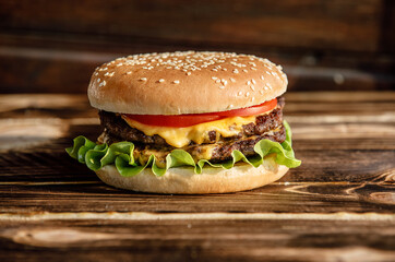Cheeseburger with double meat on wooden background. Homemade cheeseburger. Can be used for restaurant, cafe, food truck menu. Burger for ads. Burger for bigboard. Cheeseburger with 2 meat. Fast food. 