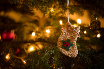 Traditional Advent Calendar Stocking with the date of the 21st of December hanging on a traditional christmas tree.