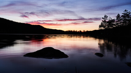 A beautiful lake and the sun has set. Bright colors and reflection in the water. shot in outside Oslo, Norway.