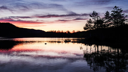 A silhoute of a rower in the beatiful horizon. The sun has set and the sky is very warm and colorful. Shot at a lake outside of Oslo, Norway Called Pershusvatnet. © SteinOve