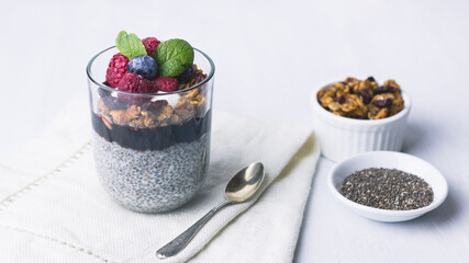 Chia pudding dessert with raspberry jam and granola, mint, blueberry, raspberry on the top