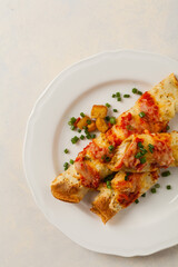 Baked pancakes with chicken in tomato sauce.