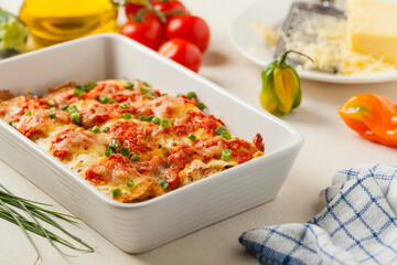 Baked pancakes with chicken in tomato sauce.