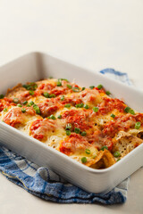 Baked pancakes with chicken in tomato sauce.