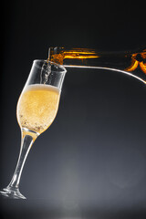 Champagne pouring into glass on black background