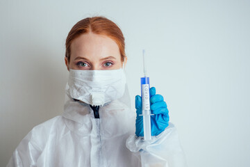 virologist woman in chemical protection mask ,glasses and gloves holding potential vaccine at the lab