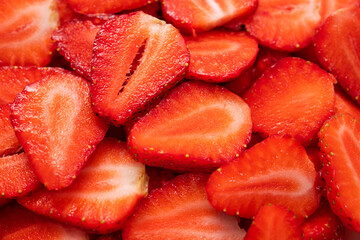 Closeup of juicy sliced strawberries on background