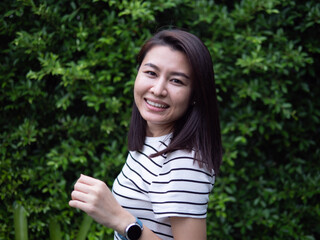 Portrait of beautiful young healthy asian woman with sportswear at green