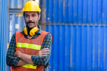 Young confident man engineer using digital tablet and wearing yellow safety helmet and check for control loading containers box from Cargo freight ship for import and export, transport.