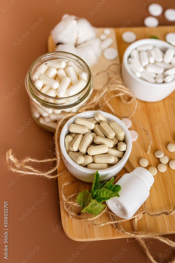 Wall mural Herbal nutrition supplements and vitamins on brown background. Healthy lifestyle and care about immunity.