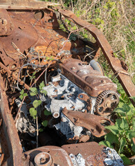 A burnt-out engine of a car in a countryside setting