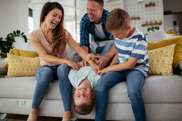 Young family enjoying at home. Happy parents with sons having fun.