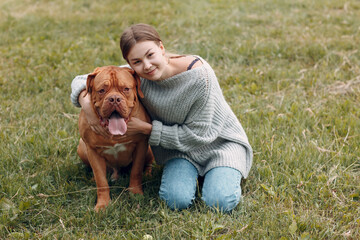 Dogue de Bordeaux or French Mastiff with young woman at outdoor park