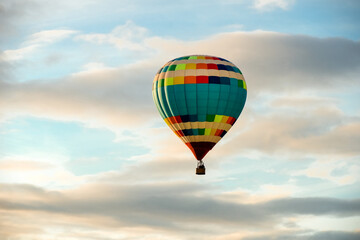 Colorful big hot air balloon flying against the cloudy sky