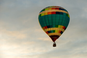 Colorful big hot air balloon flying against the cloudy sky