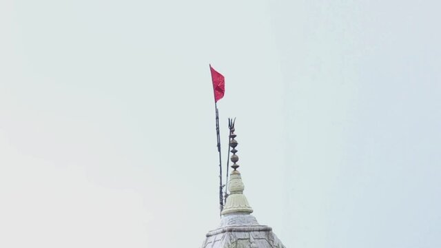 A pigeon flies away from the top of a Hindu temple structure in Mussoorie, India, slow motion shot.