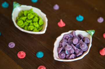 Close up purple and green homemade Allure Thai candy in a mini bowl on a rustic wooden table, Allure is traditional Thai desserts sweet and delicious.